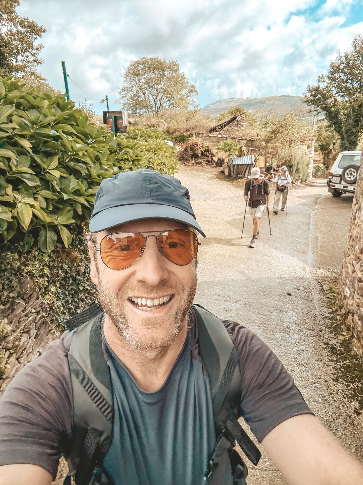 Sebastian Grote mit Kappe und Rucksack auf einem Feldweg am Jakobsweg