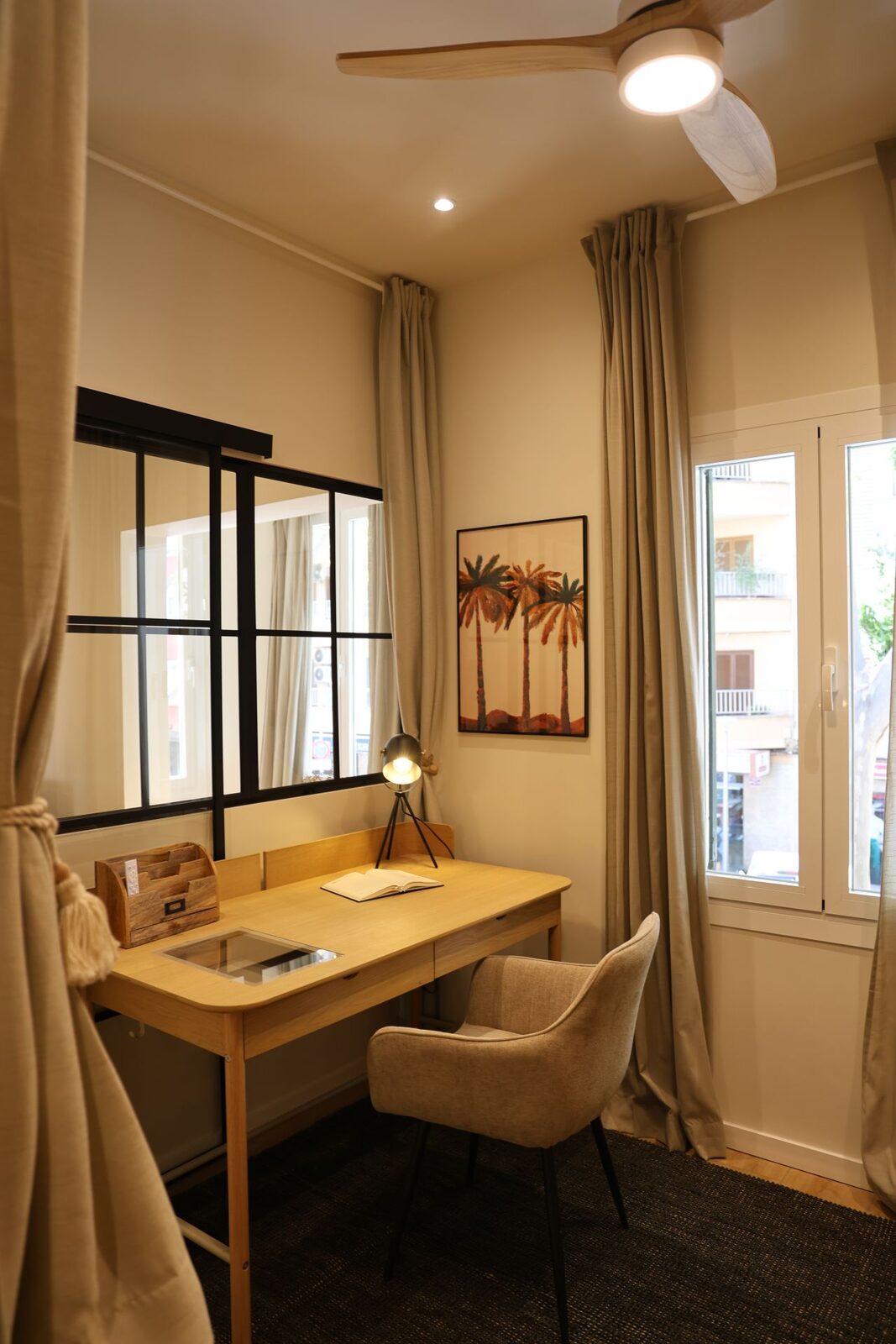 Arbeitsplatz mit Holzschreibtisch und Sprossenfenster in einer sanierten Isleño-Wohnung